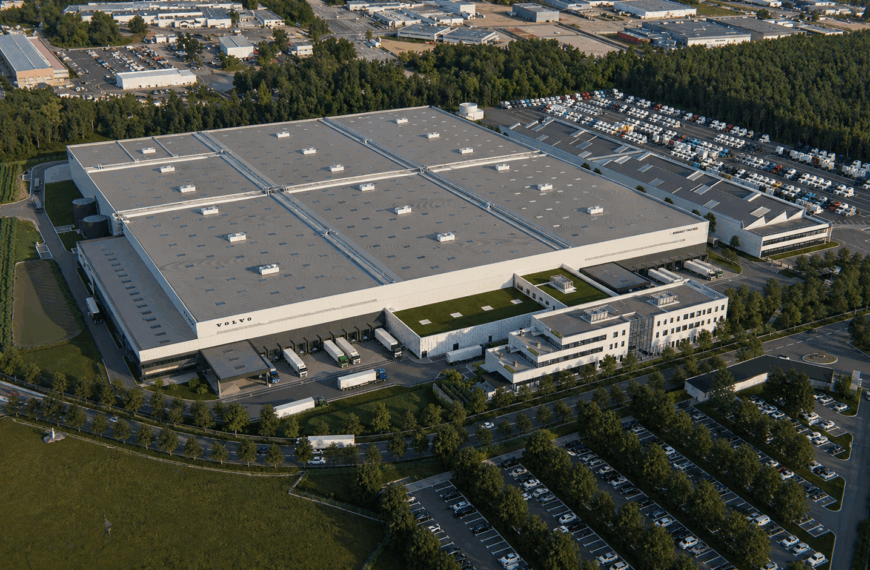 Vue aérienne de la plateforme logistique Renault Trucks à Saint-Priest, avec bâtiment de stockage, bureaux et quais de chargement.